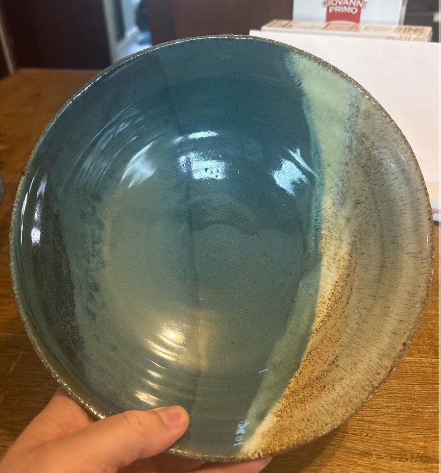 Layered bowl, fired — the aqua interior, held in one hand