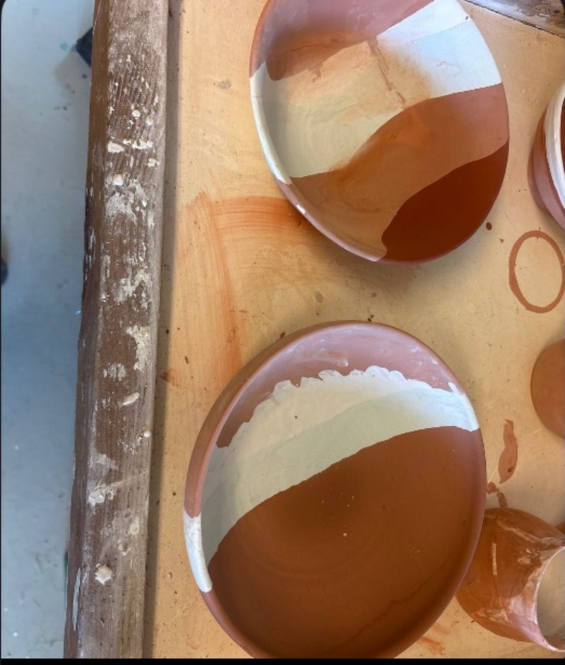 Layered ocean bowl — bisqued bowls striped terracotta and cream, laid out on the board