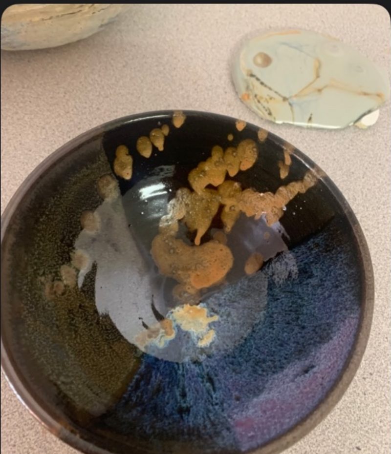 starry night + autumn bowl, from above — near-black glaze with orange blobs pooled in it