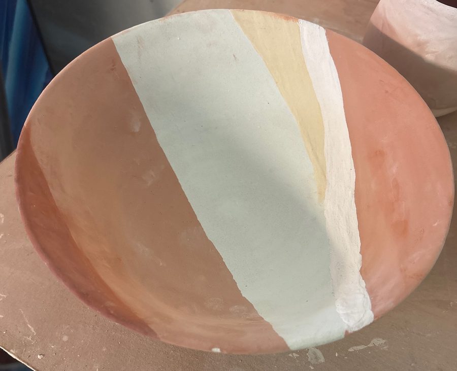 Layered bowl, unfired — stripes of pink, pale aqua, yellow and cream on the bench