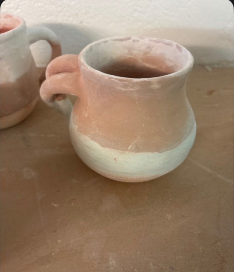 Experimental mug — a pale two-tone jug-mug on the bench, glaze half-dipped