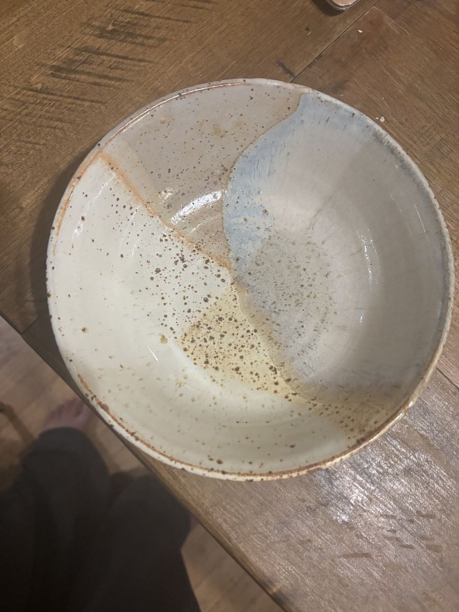 The same speckled bowl on a wooden table, the pale blue section turned the other way