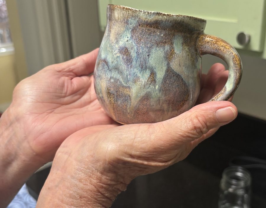 ocean mug — glazed, held in two hands, blues poured over brown